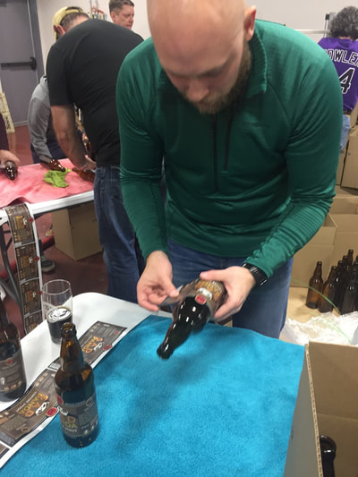 People applying bottle labels by hand.