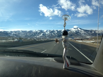 Mountains out the front window of a car (Elvis figurine dancing in windshield).
