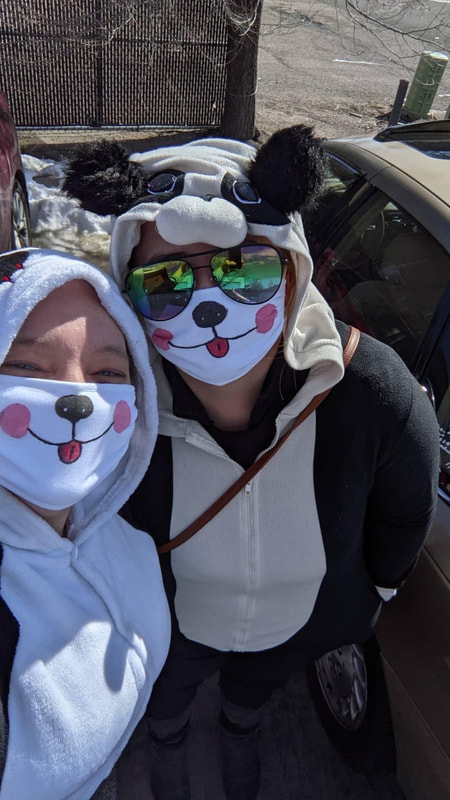 2 women wearing panda masks.