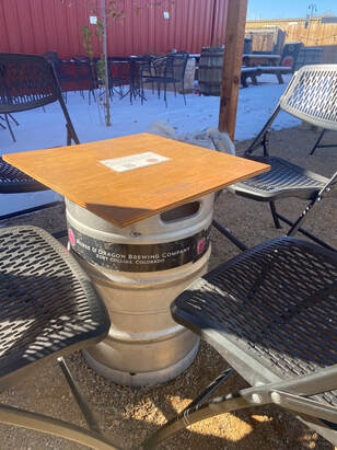 Picture of keg with plywood slab on top for a table