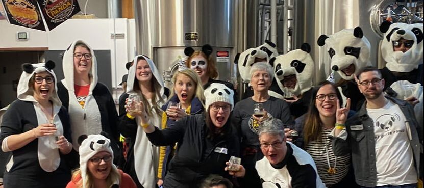 people celebrating in the brewery with panda costumes on