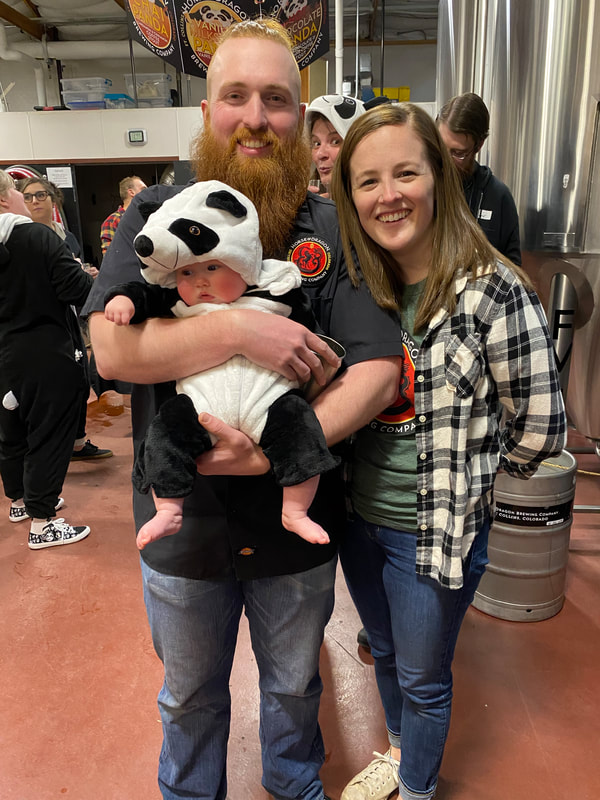 Couple and a baby in a panda costume.