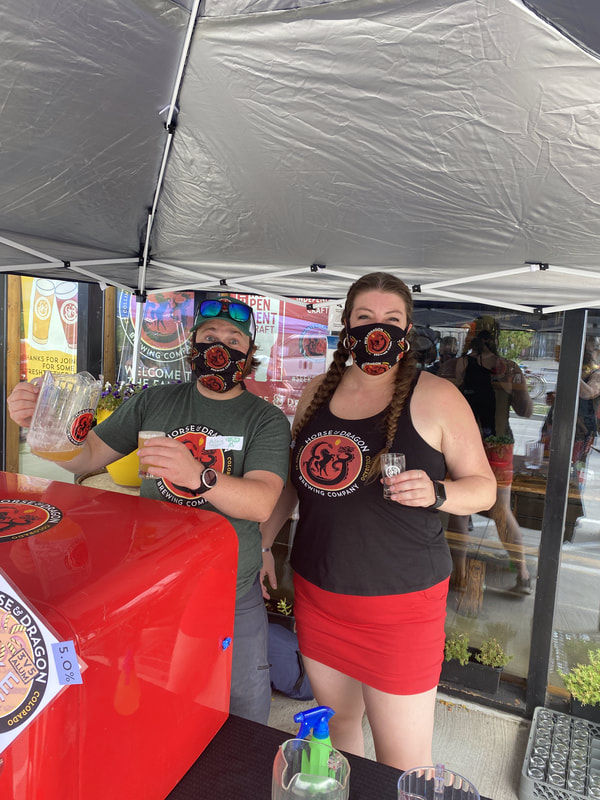 Couple serving beer with masks on.