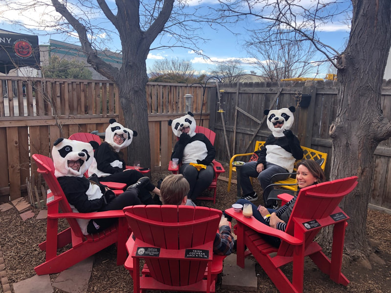 Pandas enjoying a beer in the red chairs outside.