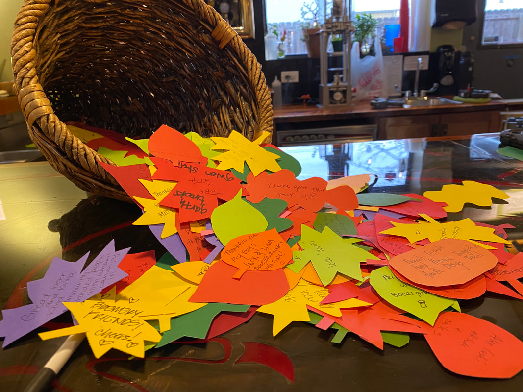 Picture of cornucopia-shaped basket spilling out pieces of paper with different gratitudes written on them